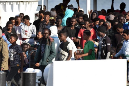 Los refugiados hacen cola para desembarcar en el puerto de Catania, Sicilia.-/ AFP / GIOVANNI ISOLINO