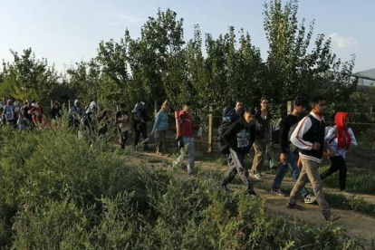 Un grupo de refugiados camina en los alrededores de Sid, cerca de la frontera con Croacia.-REUTERS / ANTONIO BRONIC