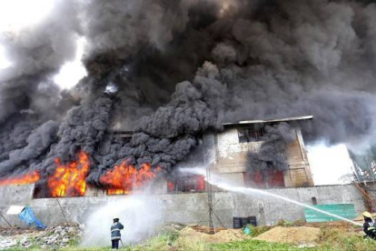 Los bomberos tratan de apagar el fuego declarado en una fábrica de zapatos de Manila.-Foto: AFP
