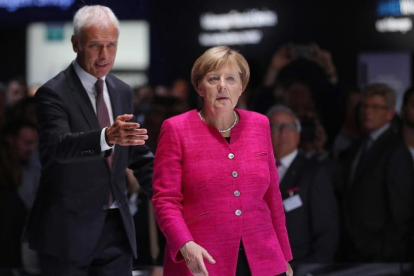 Merkel (derecha) y Matthias Mueller, presidente de Volkswagen, en el Salón Internacional del Automóvil de Fráncfort, el 14 de septiembre.-GETTY IMAGES / SEAN GALLUP