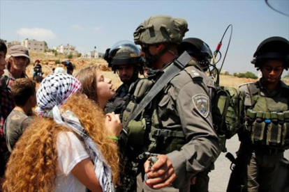 Ahed Tamimi se encara a soldados israelís, en Nabi Saleh, en mayo.-AFP/ABBAS MOMANI