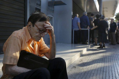 Giorgos, un pensionista de 77 años de Atenas, espera fuera del Banco Nacional de Grecia.-Foto: REUTERS / YANNIS BEHRAKIS
