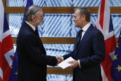 El embajador británico en la UE, Tim Barrow, entrega la carta de Theresa May al presidente del Consejo Europeo, Donald Tusk.-YVES HERMAN / REUTERS