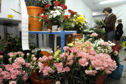 Una mujer prepara centros de flores en un establecimiento de Soria, ayer. / ÚRSULA SIERRA-