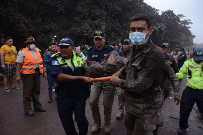 Los equipos de rescate trasladan a un herido tras la erupción del volcán de Fuego, en el municipio de El Rodeo, prácticamente arrasado.-NOE PÉREZ (EFE)