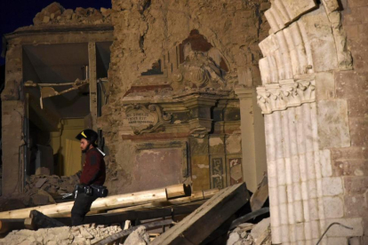 Un bombero trata de recuperar objetos de la basílica de San Benedetto, en Norcia, dañada por los terremotos.-EFE / PIETRO CROCCHIONI