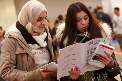 Dos mujeres visitan la segunda feria del trabajo para los inmigrantes y los refugiados celebrada en Berlín en el 2015.-REUTERS/ FABRICIO BENSCH