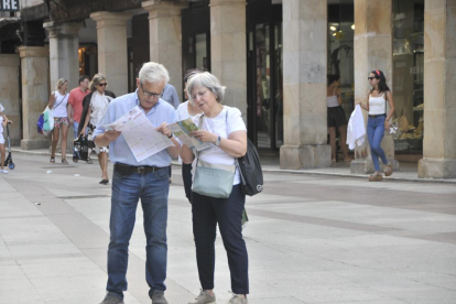 Unos turistas consultan los folletos informativos en El Collado.-Valentín Guisande