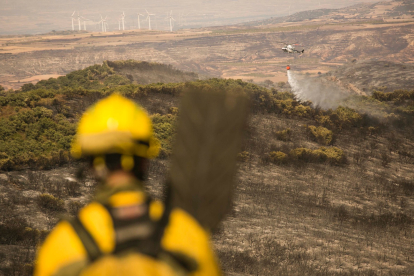Un bombero forestal observa la descarga de un helicóptero. INFOAR
