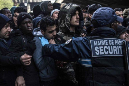 Momentos de tensión durante el desalojo de migrantes y refugiados en un campamento en París.-AFP