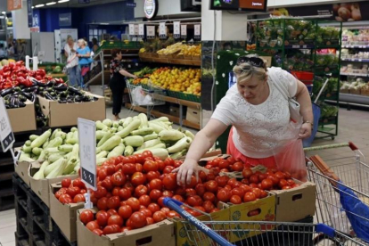 Una mujer compra tomates en un supermercado de Moscú.-YURI KOCHETKOV