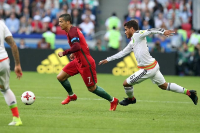 Ronaldo se va de Jonathan Dos Santos en el primer tiempo del Portugal-México.-EFE / TOLGA BOZOGLU