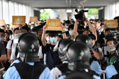 Un grupo de manifestantes sostienen pancartas de protesta contra la policía hongkonesa, este jueves.-EDWIN KWOK (EFE)