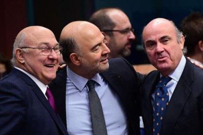 Sapin, Moscovici y Guindos, en Bruselas, durante la reunión del Eurogrupo del lunes..-AFP / EMMANUEL DUNAND