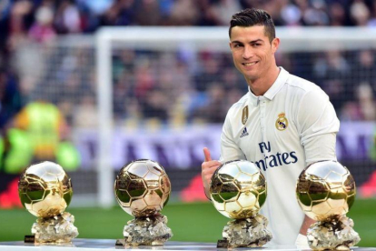 Cristiano Ronaldo posando junto a sus balones de oro.-AFP / GERARD JULIEN