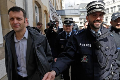 Edouard Perrin (izquierda), escoltado por la policía tras la primera jornada del juicio sobre el 'caso LuxLeaks', en Luxemburgo, este martes.-VINCENT KESSLER