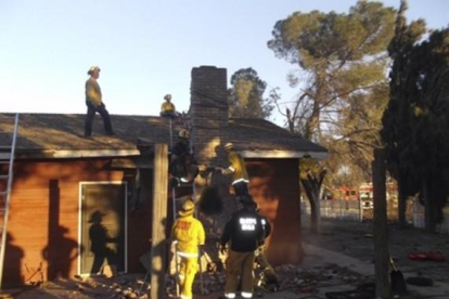 Los bomberos, tras desmontar la chimenea para rescatar el cadáver del presunto ladrón, en Fresno (California).-REUTERS