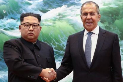 El mandatario norcoreano Kim Jong-un y el ministro de Exteriores ruso Sergéi Lavrov se estrechan la mano durante una reunión en Pionyang este jueves.-VALERY SHARIFULIN (AFP)