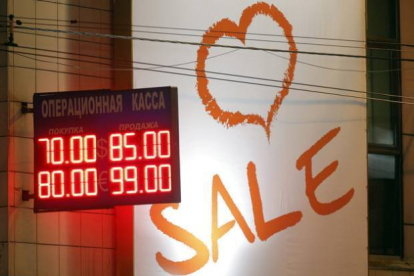 Oficina de cambio de divisas junto a un letrero de un centro comercial, el martes en Moscú.-Foto: EFE / MAXIM SHIPENKOV