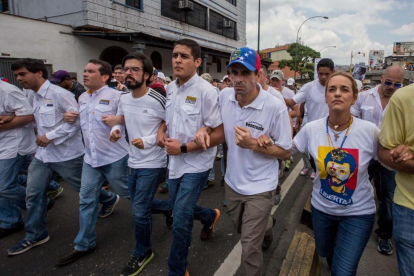 El líder opositor Henrique Capriles (segundo por la derecha) y la esposa del líder opositor Leopoldo López, Lilian Tintori, participan en una manifestación contra el gobierno nacional.-MIGUEL GUTIERREZ