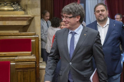 El presidente de la Generalitat, Carles Puigdemont, y el vicepresidente del Govern, Oriol Junqueras, en el hemiciclo del Parlament.-FERRAN SENDRA