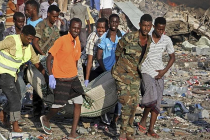 Traslado de un cadáver del lugar donde se ha producido uno de los atentados con bomba en Mogadiscio.-FARAH ABDI WARSAMEH / AP