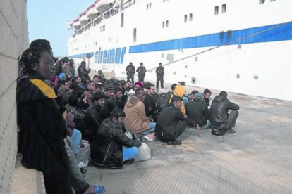 Grupos de inmigrantes esperan a ser trasladados desde Lampedusa a Sicilia.-Foto: ANA ALBA