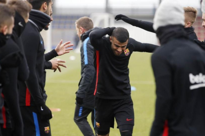 Los jugadores del Barça saludan a Rafinha, en su regreso a los entrenamientos.-EL PERIÓDICO