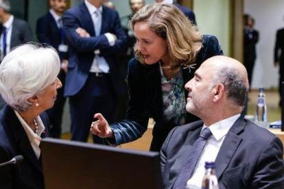 La ministra Nadia Calviño (de pie) conversa con la presidenta del BCE, Christine Lagarde, y el comisario europeo de Asuntos Económicos, Pierre Moscovici, en Bruselas.-AFP / ARIS OIKONOMOU