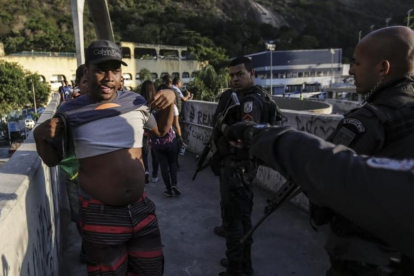 Agentes de la policia patrullan frente a la favela Rocinha durante una marcha de los habitantes pidiendo paz, el jueves 19 de octubre de 2017 , en Río de Janeiro, Brasil.-EFE / ANTONIO LACERDA