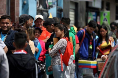 Refugiados venezolanos esperan en lla cola de la oficina de inmigración en Lima.-MARIANA BAZO (REUTERS)