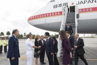 El primer ministro japones, Shinzo Abe, en el centro, es recibido por un comandante estadounidensse a su llegada a Pearl Harbor.-EFE / JAY CHU