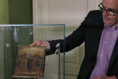Un experto muestra el cuadro de Cimabue subastado en París.-AP / MICHEL EULER