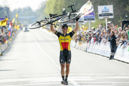 Philippe Gilbert cruza la meta de Flandes con la bici a cuestas.-JULIEN WARNAND