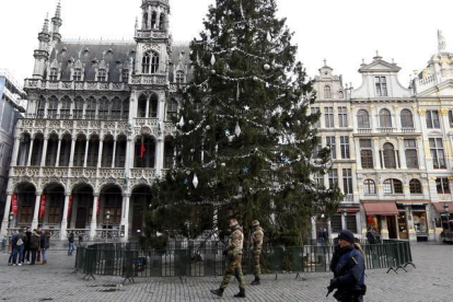 Soldados belgas caminan cerca de un arbol de navidad en la Gran Plaza de Bruselas. REUTERS / FRANCOIS LENOIR