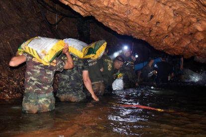 Varios miembros de un equipo de rescate intentan drenar el agua de la cueva Tham Luang en Khun Nam Nang Non Forest Park (Tailandia).-ROYAL THAI ARMY HANDOUT (EFE)