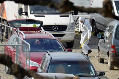Un forense examina elcoche rojo del fallidoatentado de Amberes.-REUTERS / MARC DE ROECK