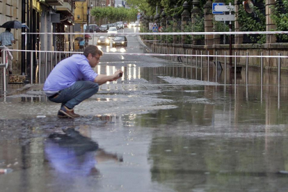 Un hombre fotografía el nivel del agua junto a un extremo cortado de Nicolás Rabal el lunes día 8.-LUIS ÁNGEL TEJEDOR