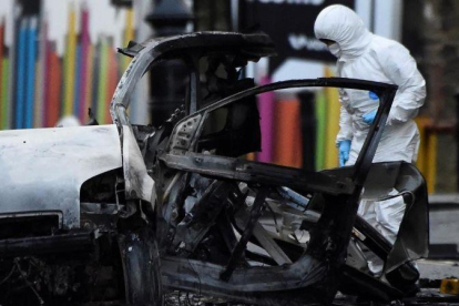 Un forense inspecciona la zona donde ha explotado el coche bomba en Londonderry.-CLODAGH KILCOYNE (REUTERS)