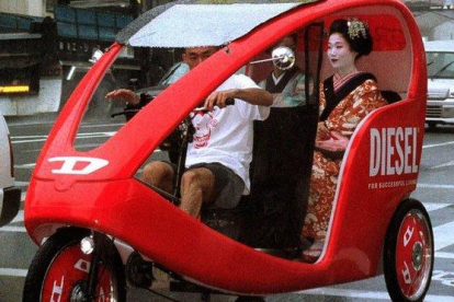 Una geisha se desplaza en un taxi triciclo por Kioto.-ISAO MORISHITA (AP)