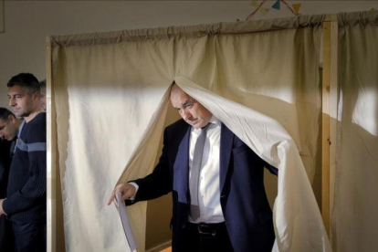 Borisov, líder del centroderechista GERB, tras votar en una cabina electoral, en Sofía, el 26 de marzo.-AP / VADIM GHIRDA