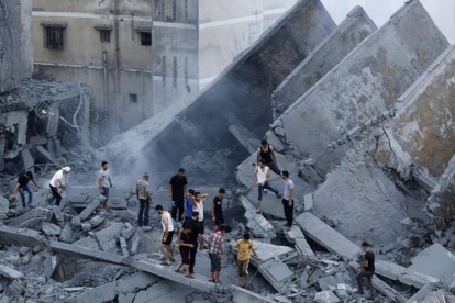 Palestinos inspeccionan los restos de Al-Basha, un edificio que fue destruido por un ataque aéreo israelí en Gaza-Foto:   AFP PHOTO / MOHAMMED ABED