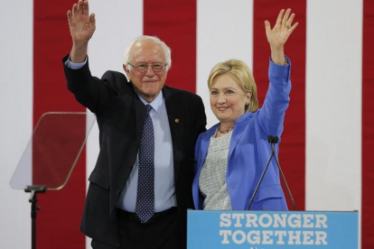 Sanders y Clinton saludan juntos a la audiencia del acto celebrado en Portsmouth (Nuevo Hampshire), este martes.-EFE / CJ GUNTHER