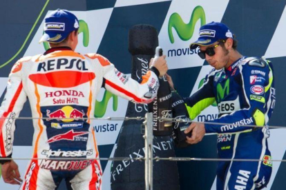 Marc Márquez y Valentino Rossi brindan en el podio de Motorland.-AFP / JAIME REINA
