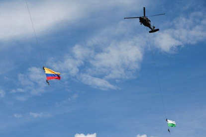 Soldados colombianos colgados de unas cuerdas en un espectáculo militar.-AFP