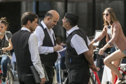 Tres camareros, durante su jornada laboral en un establecimiento de la plaza Reial de Barcelona-JOAN PUIG