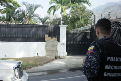Un policía venezolano frente a la Embajada española en Caracas.-CARLOS EDUARDO RAMÍREZ (REUTERS)