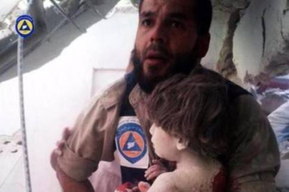 Un miembro del servicio de emergencias rescata a un niño víctima de los bombardeos rusos.-