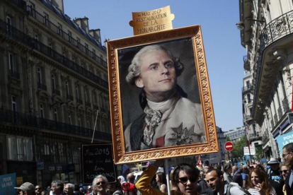 Los manifestantes contrarios a Macron muestran un retrato del rey Luis XIV con la cara del actual presidente.-/ FRANÇOIS MORI / AFP