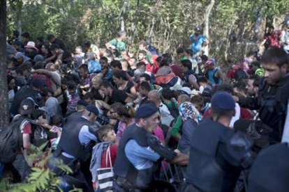 Inmigrantes y refugiados rompen el cordón policial en Tovarnik, este jueves.-